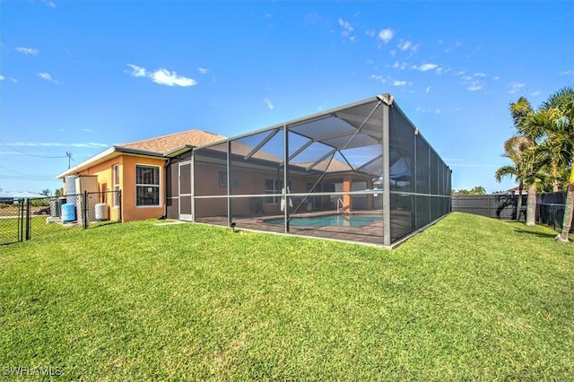 rear view of property featuring a fenced in pool, a yard, and glass enclosure