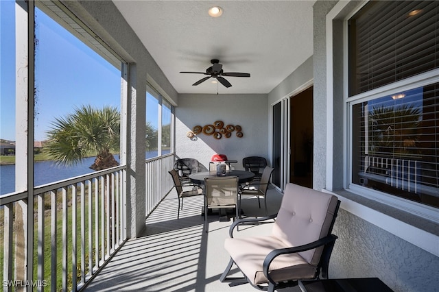 sunroom / solarium with a water view and ceiling fan