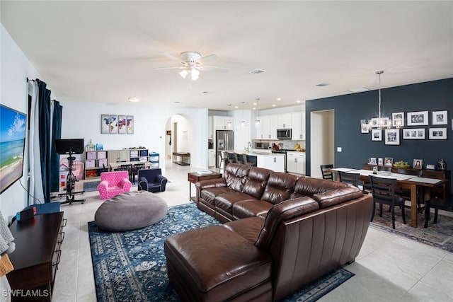 living room featuring ceiling fan with notable chandelier