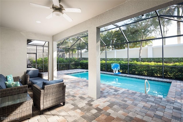 view of swimming pool featuring a patio, outdoor lounge area, ceiling fan, and glass enclosure