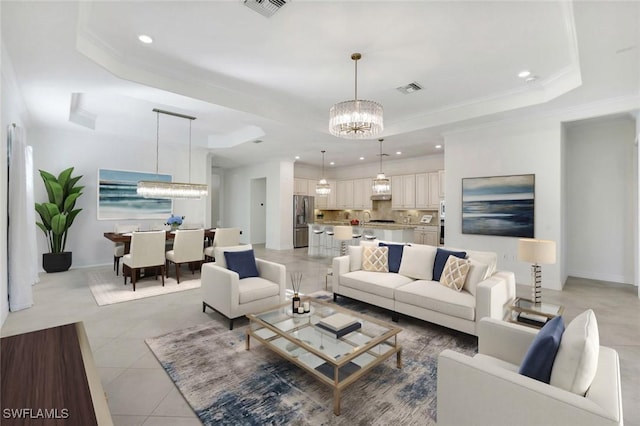 living room featuring an inviting chandelier, light tile patterned floors, ornamental molding, and a raised ceiling