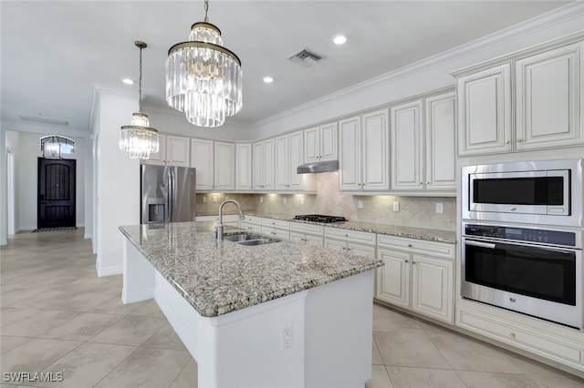 kitchen featuring an island with sink, sink, white cabinets, a notable chandelier, and stainless steel appliances