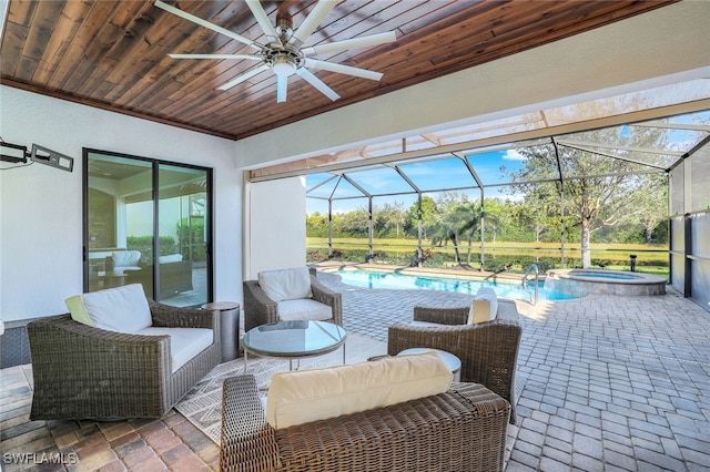 view of patio featuring ceiling fan, an outdoor living space, a swimming pool with hot tub, and glass enclosure