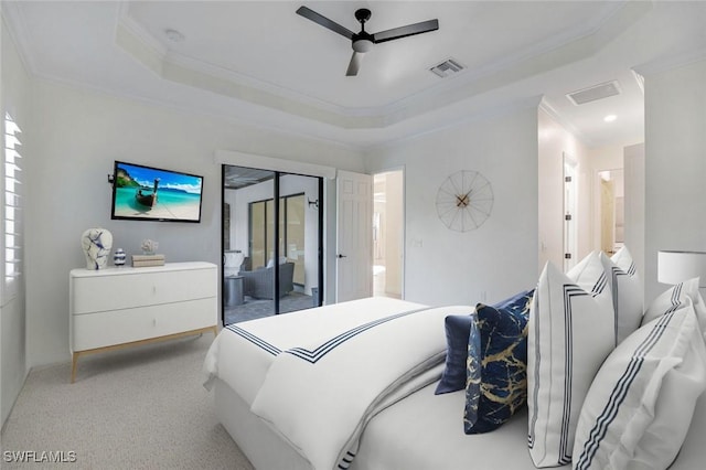 carpeted bedroom with ceiling fan, ornamental molding, and a tray ceiling