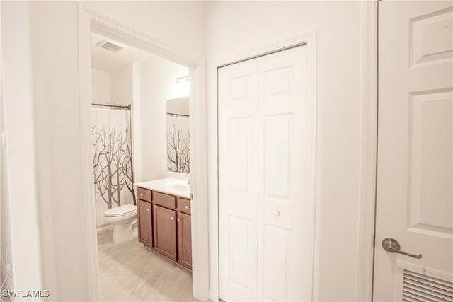 bathroom featuring vanity, a shower with curtain, tile patterned floors, and toilet