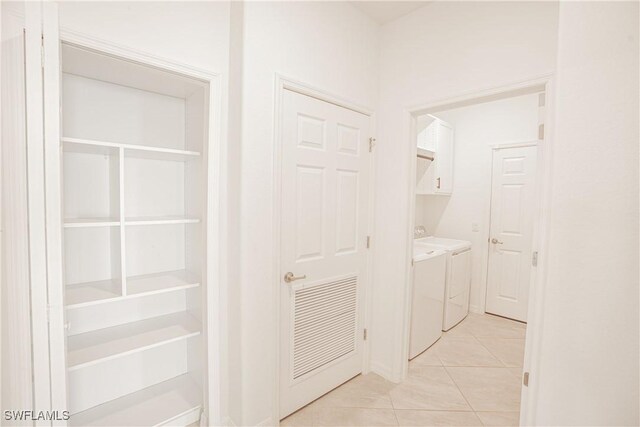 washroom with cabinets, light tile patterned flooring, and washer and dryer