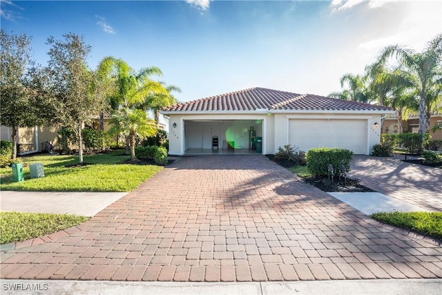 mediterranean / spanish-style house with a garage and a front lawn