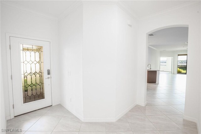 foyer entrance featuring light tile patterned flooring and ornamental molding