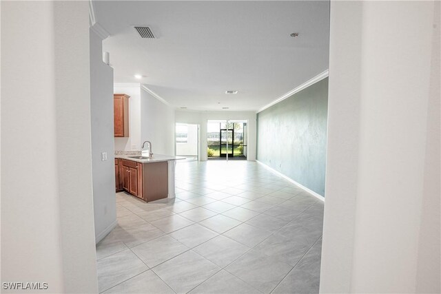 hallway featuring ornamental molding, sink, and light tile patterned flooring