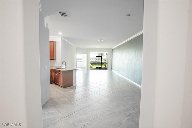 hall featuring light tile patterned flooring, ornamental molding, and sink