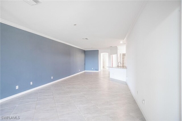 tiled spare room featuring ornamental molding