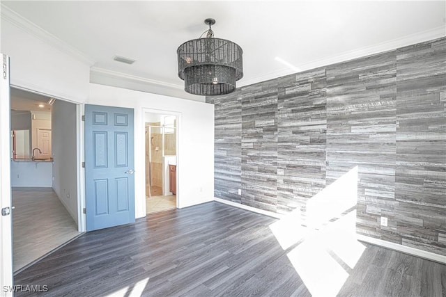 spare room with sink, crown molding, dark hardwood / wood-style floors, and a chandelier