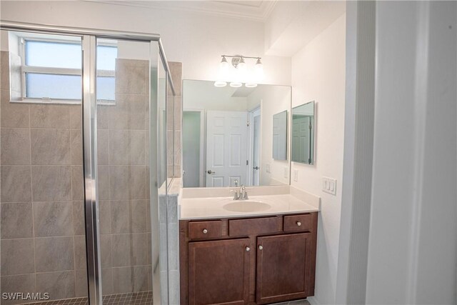 bathroom featuring crown molding, vanity, and a shower with shower door