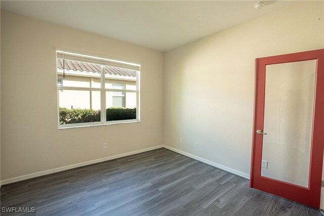 unfurnished room with dark hardwood / wood-style flooring