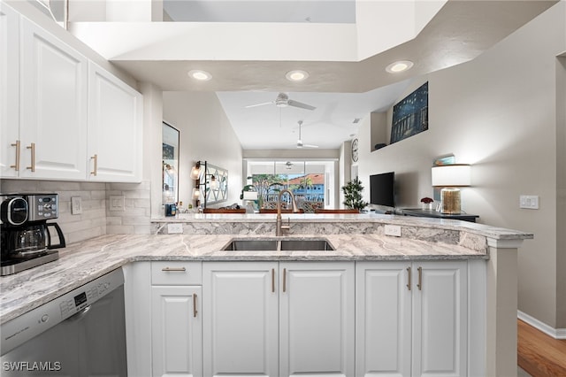 kitchen with sink, dishwasher, light stone countertops, white cabinets, and kitchen peninsula