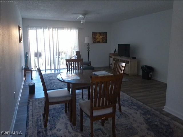 dining area with dark wood-type flooring and ceiling fan