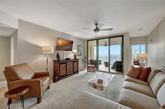 living room featuring expansive windows and ceiling fan