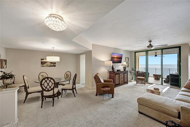 living room with expansive windows and ceiling fan