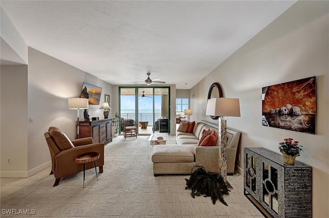 living room with light colored carpet, expansive windows, and ceiling fan