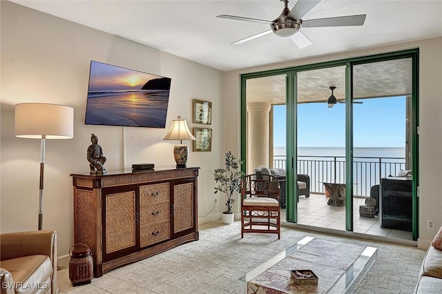 living room featuring a wall of windows and ceiling fan