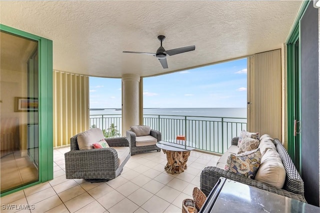 sunroom / solarium with a water view and ceiling fan