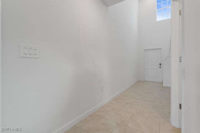 corridor with a towering ceiling and light tile patterned floors