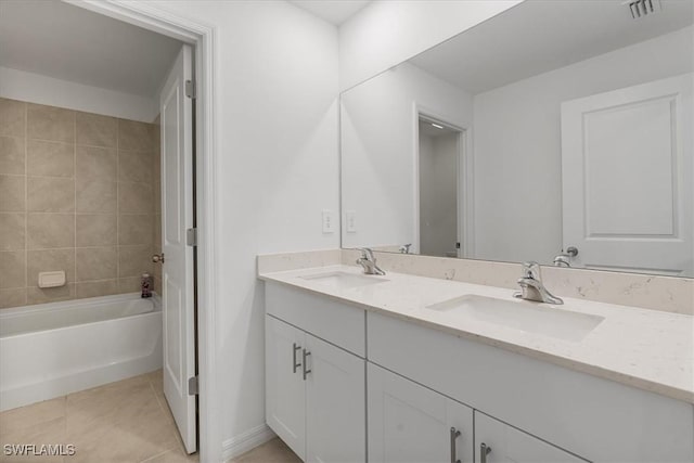 bathroom with tiled shower / bath, vanity, and tile patterned flooring