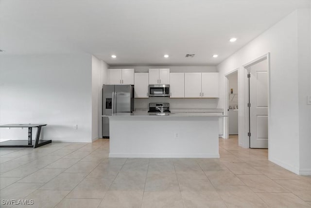 kitchen featuring white cabinetry, light tile patterned flooring, an island with sink, and appliances with stainless steel finishes