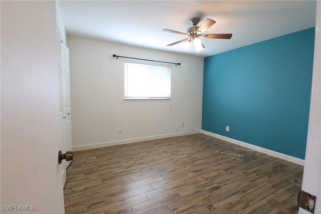 spare room featuring dark wood-type flooring and ceiling fan