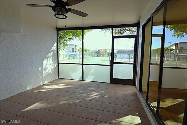 unfurnished sunroom with ceiling fan