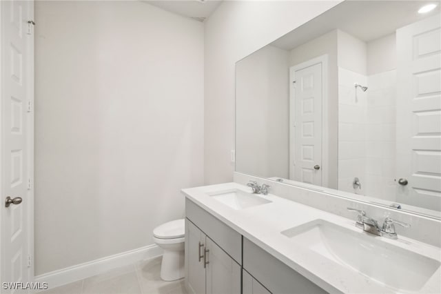 bathroom featuring tile patterned flooring, vanity, a shower, and toilet