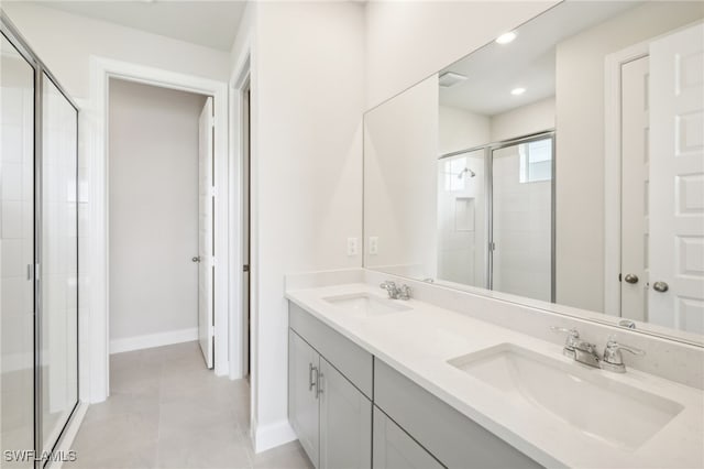 bathroom with vanity, a shower with shower door, and tile patterned flooring