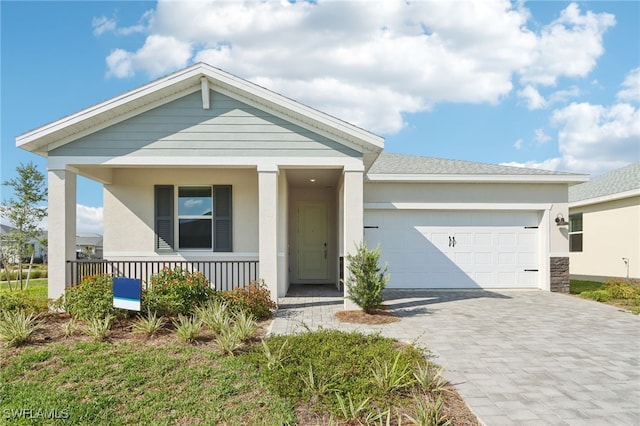 16672 Expedition Ct, Punta Gorda, FL 33982 - view of front of property with a garage, covered porch, decorative driveway, and stucco siding