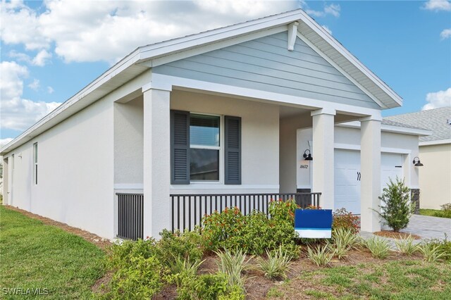 16672 Expedition Ct, Punta Gorda, FL 33982 - view of front of house with a porch, a garage, stucco siding, and driveway