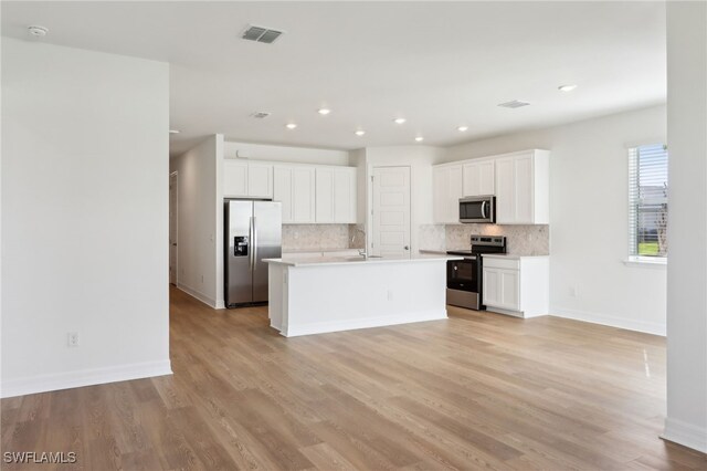 16672 Expedition Ct, Punta Gorda, FL 33982 - kitchen featuring stainless steel appliances, decorative backsplash, baseboards, white cabinets, and light wood-style floors