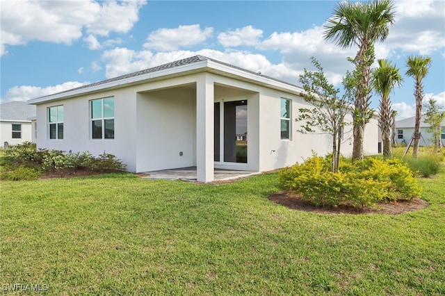 16672 Expedition Ct, Punta Gorda, FL 33982 - rear view of house with stucco siding, a yard, and a patio area