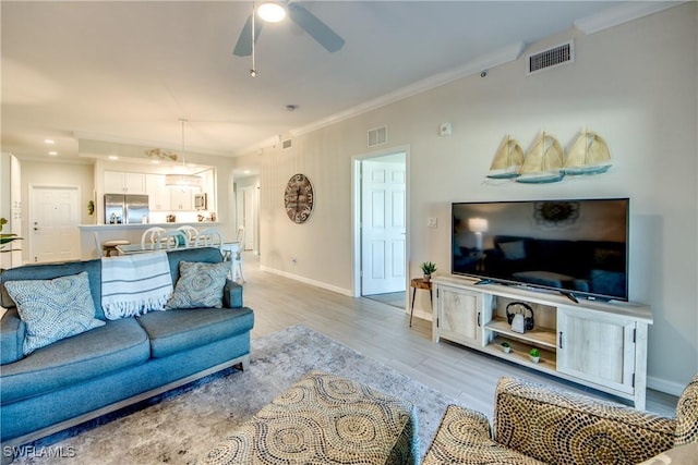 living room with crown molding, ceiling fan, and light hardwood / wood-style floors