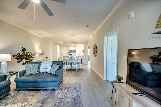 living room featuring hardwood / wood-style flooring, ceiling fan, and ornamental molding