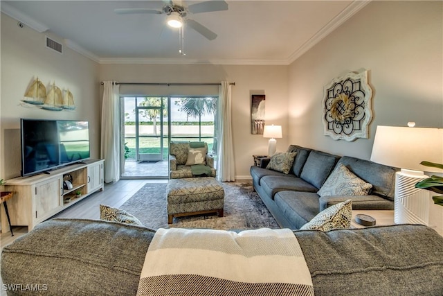 living room with crown molding, light hardwood / wood-style flooring, and ceiling fan