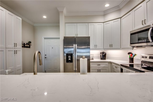 kitchen featuring white cabinetry, appliances with stainless steel finishes, and crown molding