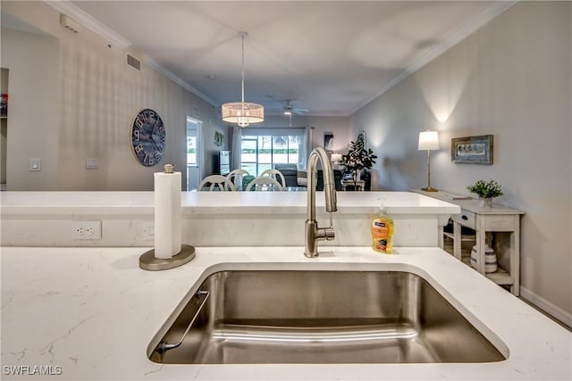 details featuring pendant lighting, ceiling fan, crown molding, and sink