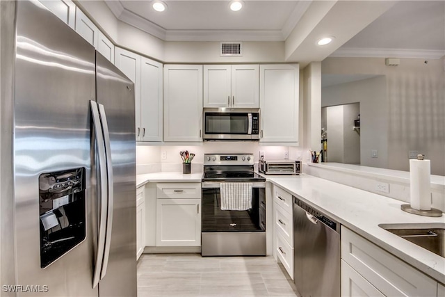 kitchen featuring crown molding, white cabinets, and appliances with stainless steel finishes