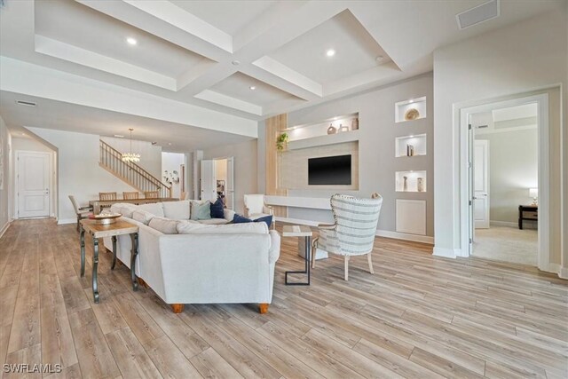 living room featuring coffered ceiling, baseboards, stairs, light wood-style floors, and beam ceiling