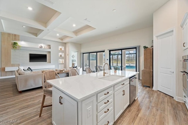 kitchen with a breakfast bar area, a sink, light wood-type flooring, coffered ceiling, and dishwasher