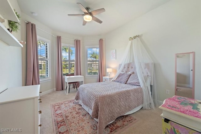 bedroom featuring light carpet, ceiling fan, and baseboards