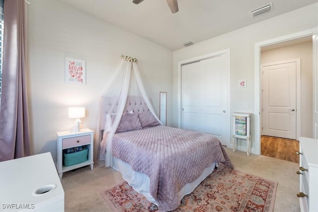 bedroom with light carpet, a closet, vaulted ceiling, and visible vents