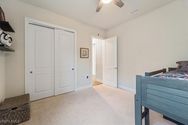 carpeted bedroom featuring baseboards, visible vents, ceiling fan, and a closet