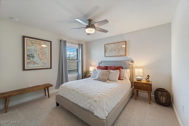 bedroom featuring light carpet, a ceiling fan, and baseboards