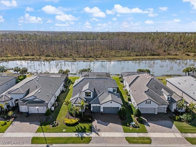 aerial view featuring a water view, a wooded view, and a residential view