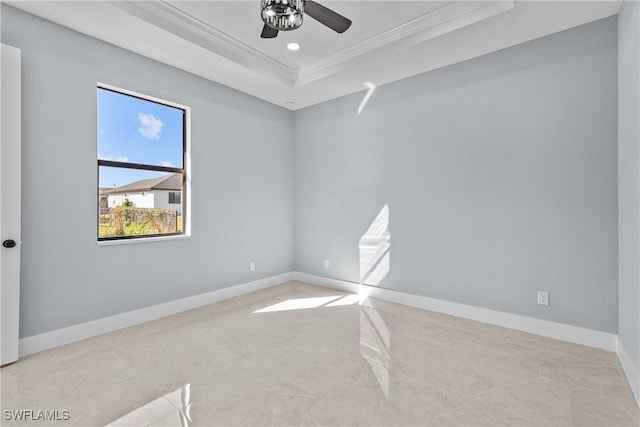 empty room with a raised ceiling, crown molding, and ceiling fan